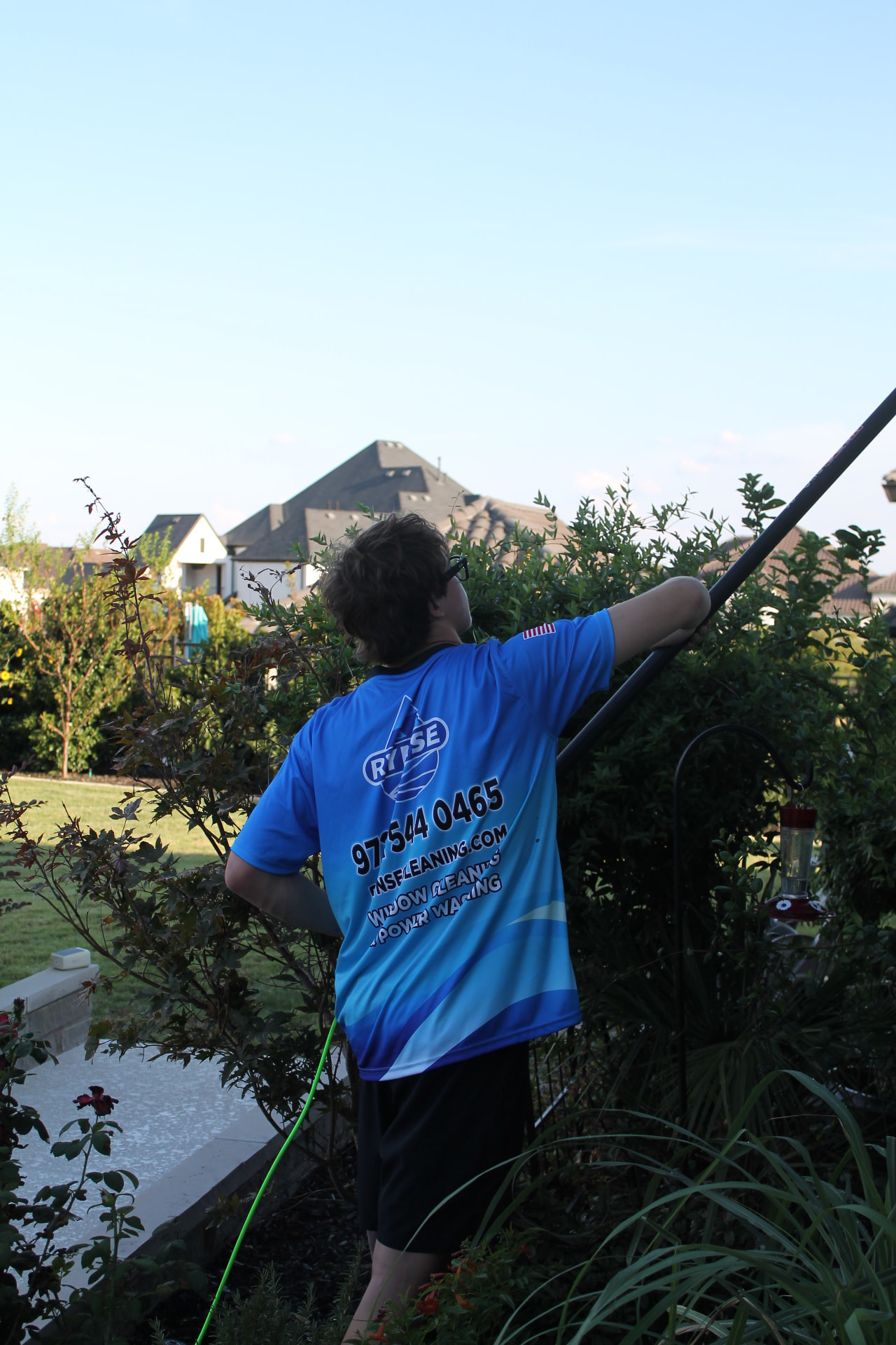 RYNSE technician washing high windows with a water-fed pole